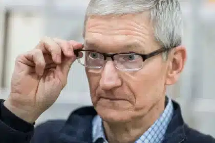 Man wearing glasses adjusting them with a focused expression.