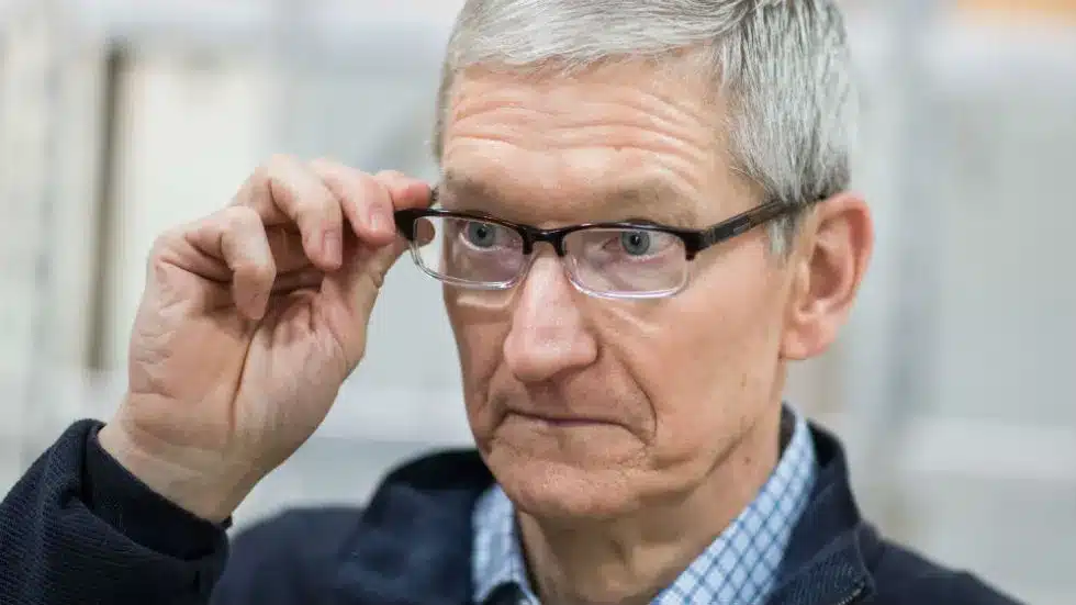 Man wearing glasses adjusting them with a focused expression.