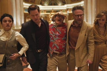 Cast of The Studio walking through a hotel lobby scene.