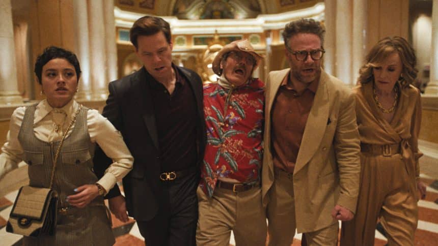 Cast of The Studio walking through a hotel lobby scene.