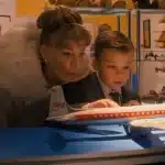 Woman and young boy looking at a vintage model airplane display.