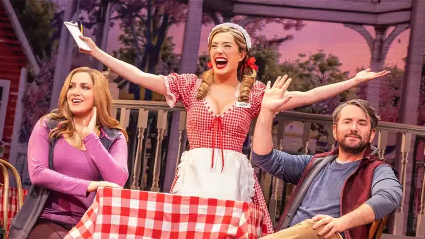 Actors performing a lively musical scene on a colourful stage.