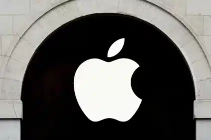 Apple logo on a black sign within a stone archway.