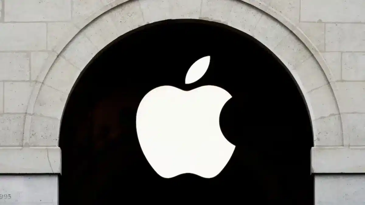 Apple logo on a black sign within a stone archway.