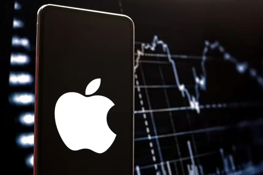Apple logo on smartphone with stock market chart background.