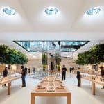 Interior of a modern Apple Store with product display tables.