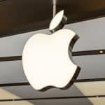 Large Apple logo hanging inside a modern retail store ceiling.