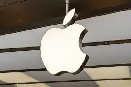 Large Apple logo hanging inside a modern retail store ceiling.