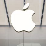 Large white Apple logo displayed on a modern glass storefront.