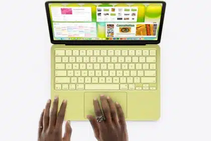 Hands using a green MacBook laptop viewed from above.