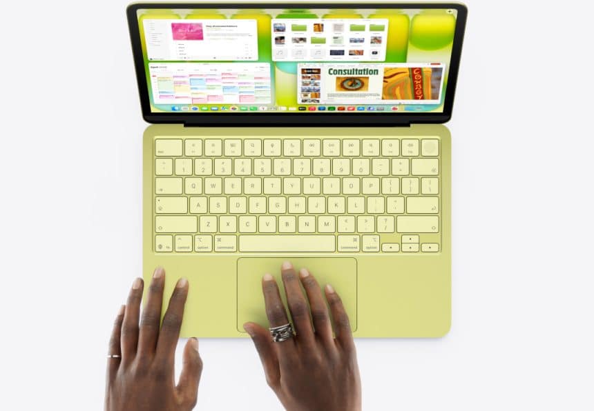 Hands using a green MacBook laptop viewed from above.