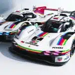 Two Porsche 963 race cars with retro Apple rainbow livery.