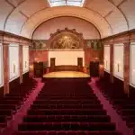 Interior view of Wigmore Hall with red seats and a concert stage.