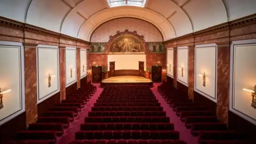 Interior view of Wigmore Hall with red seats and a concert stage.