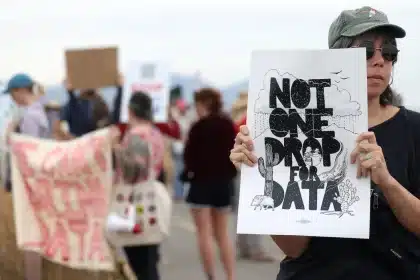 Person holding a protest sign reading “Not One Drop for Data” during a public demonstration.
