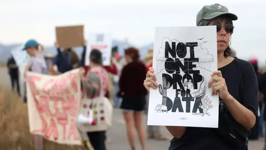 Person holding a protest sign reading &ldquo;Not One Drop for Data&rdquo; during a public demonstration.
