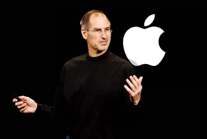 Steve Jobs presenting on stage with an Apple logo displayed behind him.