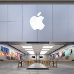 Apple Store entrance with a large illuminated Apple logo above the storefront.