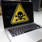 Laptop displaying a malware warning symbol on its screen.
