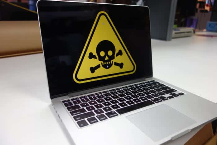 Laptop displaying a malware warning symbol on its screen.