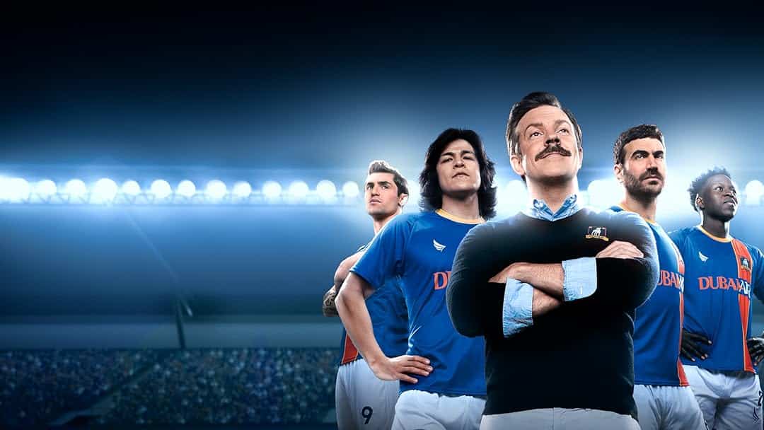 Ted Lasso and AFC Richmond team members in a stadium.