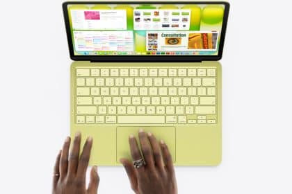 Hands using a yellow MacBook with multiple apps open on the screen.