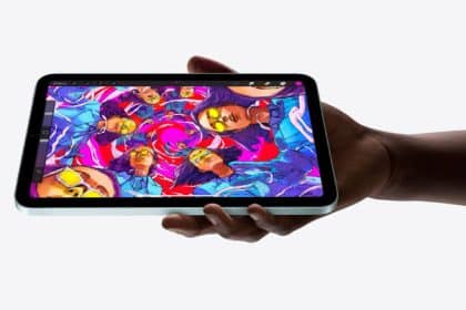 Person holding an iPad mini displaying colourful digital artwork.