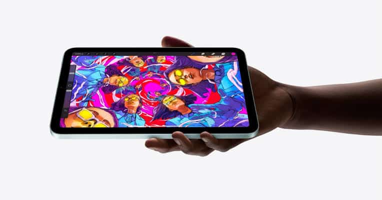 Person holding an iPad mini displaying colourful digital artwork.