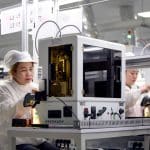 Workers operating equipment at an Apple supplier facility in Vietnam.