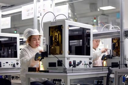 Workers operating equipment at an Apple supplier facility in Vietnam.