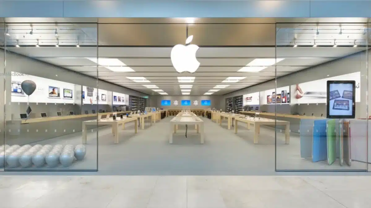 Apple Store interior with product displays and a large Apple logo.