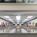 Modern Apple Store interior with product displays and wooden tables.