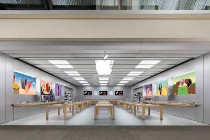 Modern Apple Store interior with product displays and wooden tables.