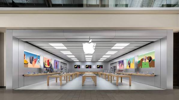 Modern Apple Store interior with product displays and wooden tables.