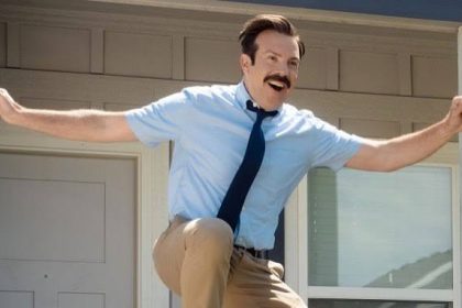 Ted Lasso celebrating with his arms raised.