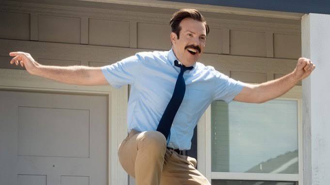 Ted Lasso celebrating with his arms raised.