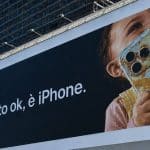 Apple billboard in Milan showing a child holding a food-covered iPhone.