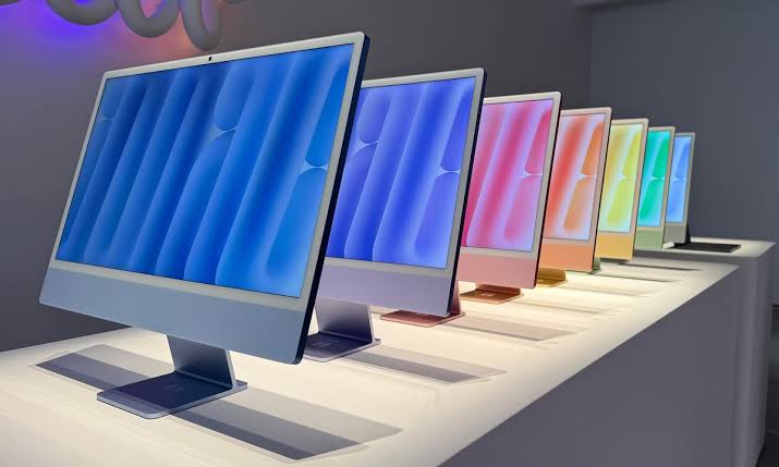 Colourful Apple iMacs displayed in a row.