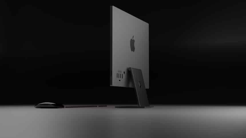 Rear view of a sleek black Apple iMac with a matching keyboard and mouse on a dark background.
