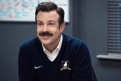 Ted Lasso smiling in an AFC Richmond sweater.