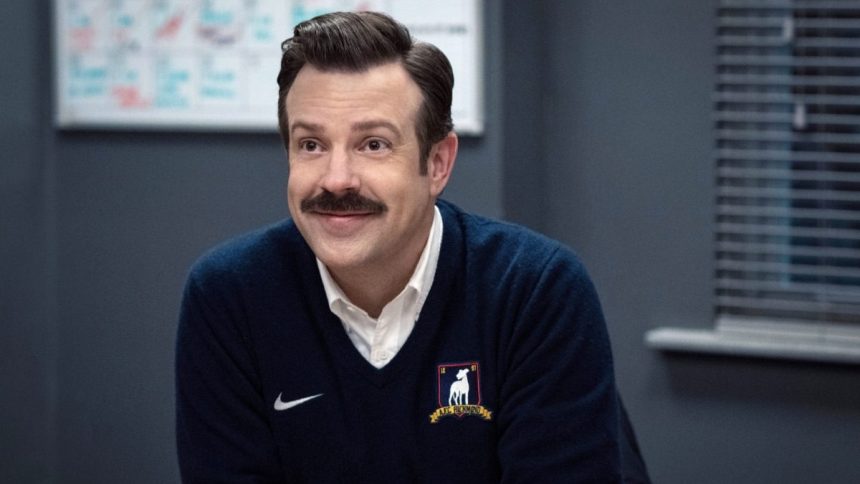 Ted Lasso smiling in an AFC Richmond sweater.