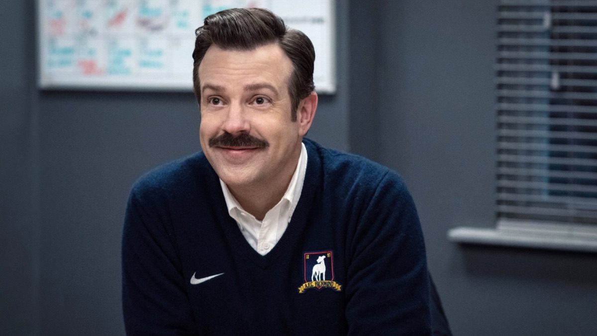 Ted Lasso smiling in an AFC Richmond sweater.