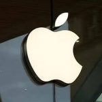 Illuminated Apple logo outside a store.