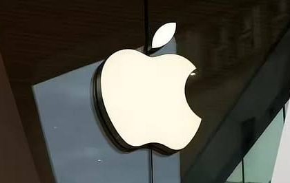 Illuminated Apple logo outside a store.