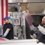 Workers inspect glass at a Kentucky manufacturing plant.