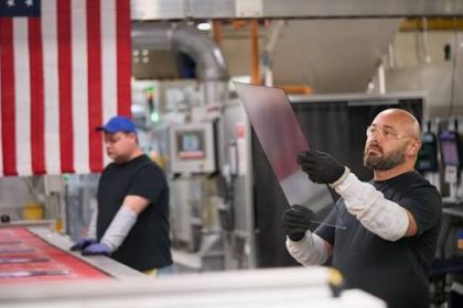 Workers inspect glass at a Kentucky manufacturing plant.