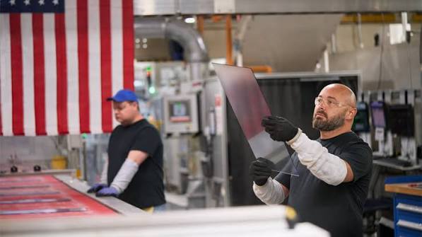 Workers inspect glass at a Kentucky manufacturing plant.
