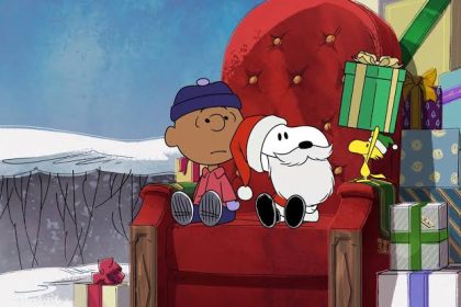Snoopy, Charlie Brown, and Woodstock sitting beside Christmas presents.