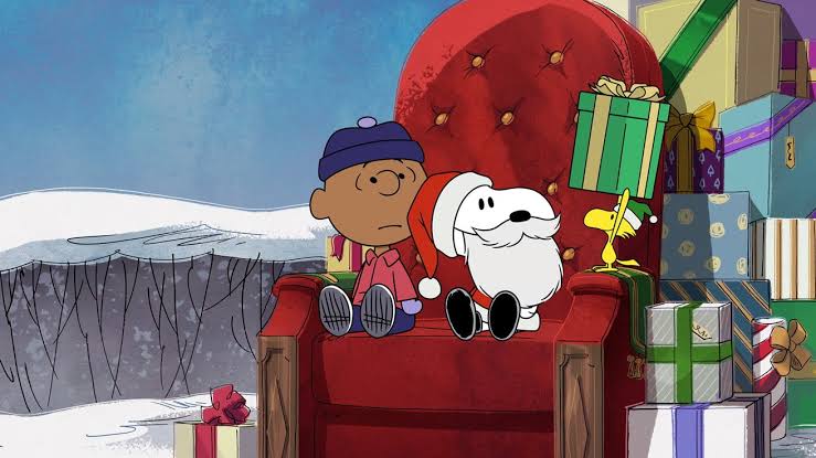 Snoopy, Charlie Brown, and Woodstock sitting beside Christmas presents.