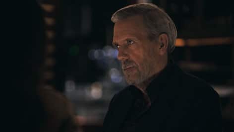 A man in a dark suit from Apple TV’s Wanted Man.